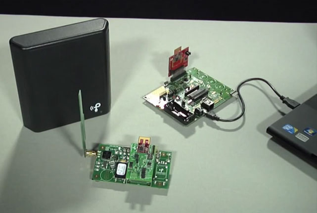 Беспроводная зарядка Powercast (слева) питает электроэнергией промышленный датчик (в середине), с которого снимаются показания (компьютер и плата справа)