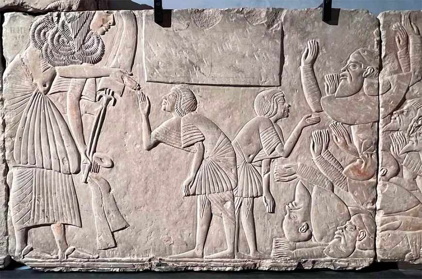 На барельефе дважды изображён Хоремхеб, генералиссимус при Тутанхамоне. Слева он получает «золото почёта», а справа перед группой иностранцев.