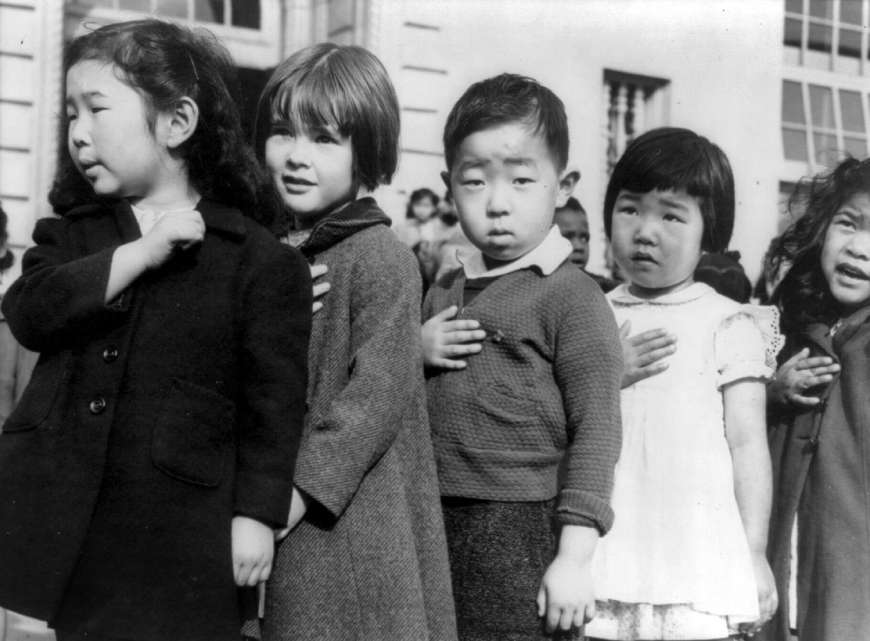 Дети средней школы Вэйл в Сан Франциско произносят клятву верности американскому флагу перед отправкой в американский концлагерь, апрель 1942 года.